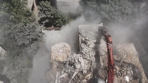 Drone shot capturing the destruction of a building by a massive bulldozer Stock Footage 294261796
