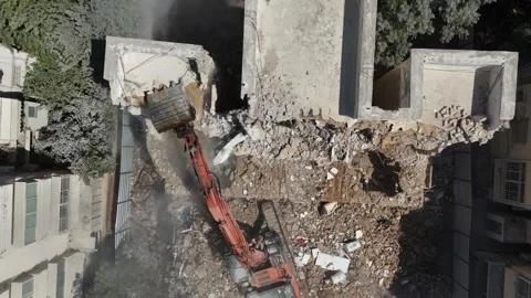 Drone shot capturing the destruction of a building by a massive bulldozer Stock Footage 294261871
