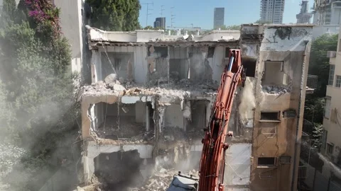 Drone shot capturing the destruction of a building by a massive bulldozer Stock Footage 294723074