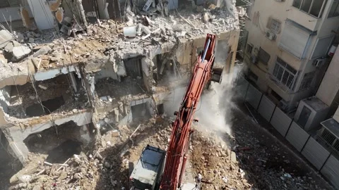 Drone shot capturing the destruction of a building by a massive bulldozer Stock Footage 294723083