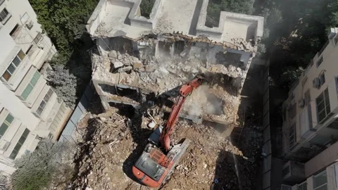 Drone shot capturing the destruction of a building by a massive bulldozer Stock Footage 294723088