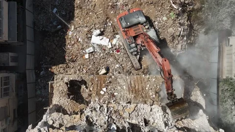Drone shot capturing the destruction of a building by a massive bulldozer Stock Footage 294723092