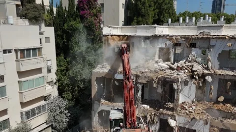 Drone shot capturing the destruction of a building by a massive bulldozer Stock Footage 294723108