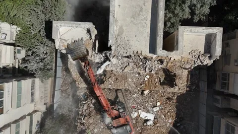 Drone shot capturing the destruction of a building by a massive bulldozer Stock Footage 294723128