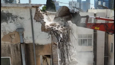 Drone shot capturing the destruction of a building by a massive bulldozer Stock Footage 294723134