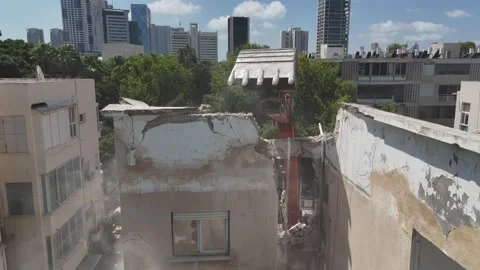 Drone shot capturing the destruction of a building by a massive bulldozer Stock Footage 294723137