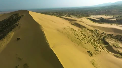 Drone shot capturing the vast Sarykum Dune, Dagestan, where golden sands and spa Stock Footage 303406653