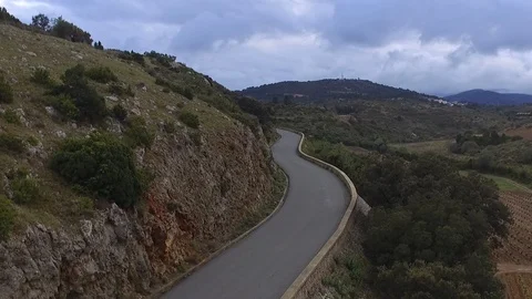 Drone shot of a car driving down the asphalt road on a mountain with mountains Vídeo Stock 108619764