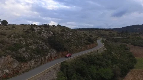 Drone shot of a car driving down the asphalt road on a mountain with mountains Stock-Footage 108619839