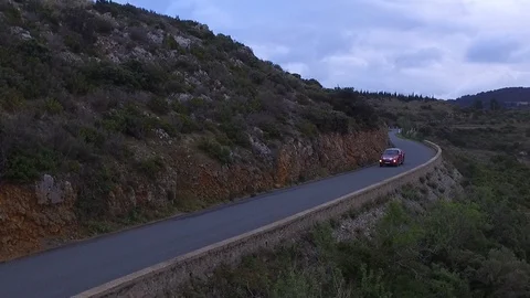 Drone shot of a car driving down the asphalt road on a mountain with mountains 스톡 동영상 108620014