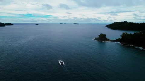 Drone shot of a catamaran motoring between islands. Stock Footage 308518630
