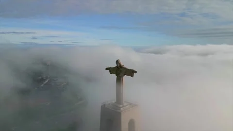Drone shot of Christ the King monument emerging from low clouds Stock Footage 346323706