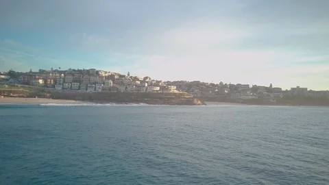 Drone shot of cityscape and waves splashing on rocky coast Stock Footage 122392557