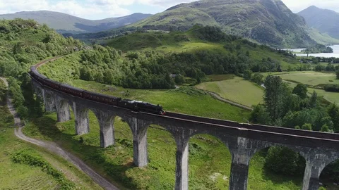 Drone shot classic steam training crossing Glenfinnan viaduct in Scotland 動画素材 99013663