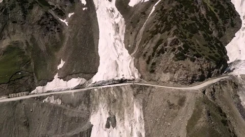 Drone shot of cliff-hugging roads at Zojila with snow walls. Stock Footage 310806692