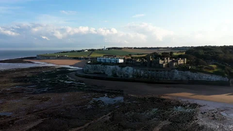 Drone shot climbing to reveal an empty beach, lighthouse and castle. Stock Footage 146741450