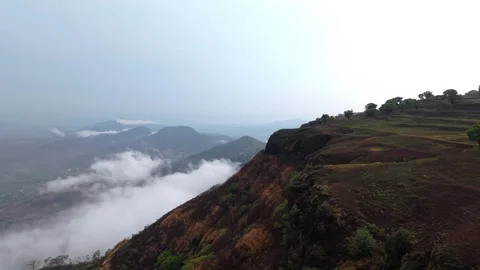 Drone shot of clouds clashing against a mountain 4K30 스톡 동영상 332893244