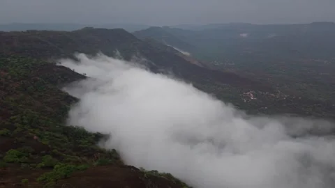 Drone shot of clouds clashing against a mountain 4K30 스톡 동영상 332893261