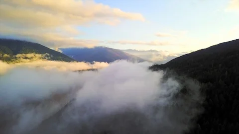 Drone shot in the clouds over a lake valley Stock Footage