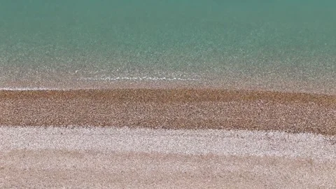 Drone shot of Coastline on a calm cloudy day, with stone beach and soft waves Stock Footage 330907452