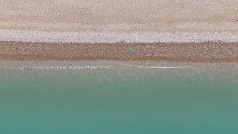 Drone shot of Coastline on a calm cloudy day, with stone beach and soft waves Stock Footage 330907525