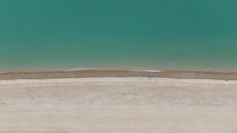 Drone shot of Coastline on a calm cloudy day, with stone beach and soft waves Stock Footage 330907529