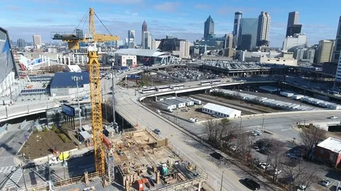 Drone shot of a construction crane spinning with the city of Atl in background Stockbeeldmateriaal 101269243