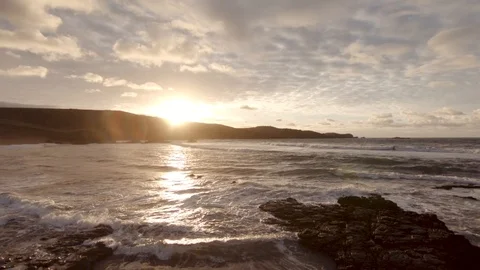 Drone shot of couple walk on empty sunset beach Video stock 121584951