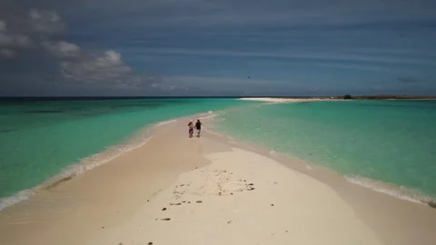 Drone shot of couple walking hand in hand across tropical sandbar at Cayo de 스톡 동영상 336707594