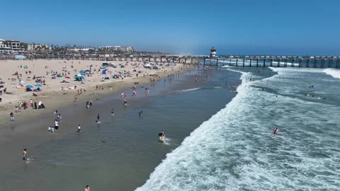 Drone shot of crowded sandy beach and surfing waves in California Stock Footage 341661139
