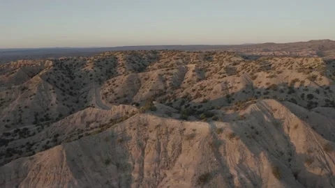 Drone shot dolly right to left of rocky foot hills in the desert at sunset Video stock 167672981