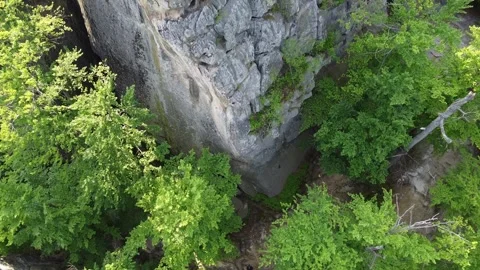 Drone shot of Dovbush Rocks cliffs above forest near river, Carpathian Mountains Stock Footage 336631705