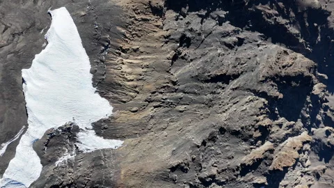 Drone shot, downward angle of Uhuru Peak on Mount Kilimanjaro with the volcanic Stock Footage 296588710