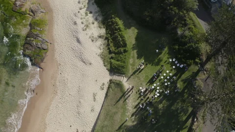 Drone shot of event by beach on grassy patch Stock Footage 282996899