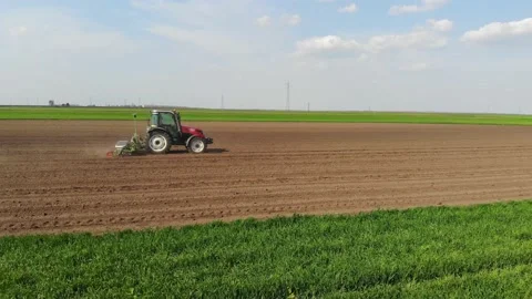 Drone shot of a farmer in tractor seeding crops Video stock 162347486