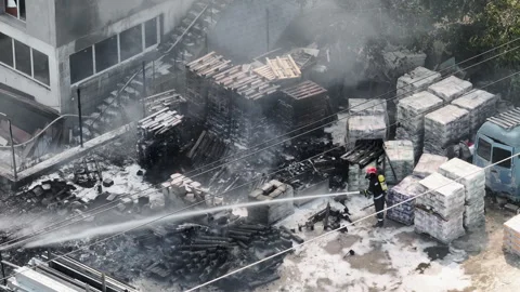 Drone shot firefighter handling high-pressure hose Stock Footage 303310548