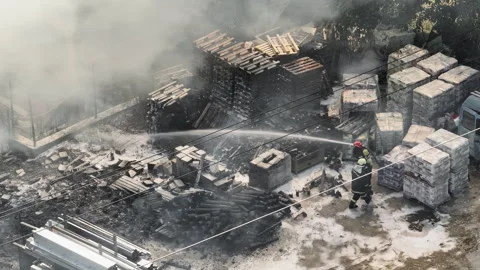 Drone shot firefighter handling high-pressure hose Stock Footage 303310601