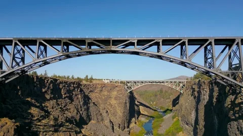 Drone shot flies over a deep valley and under a bridge Stock Footage 318476988