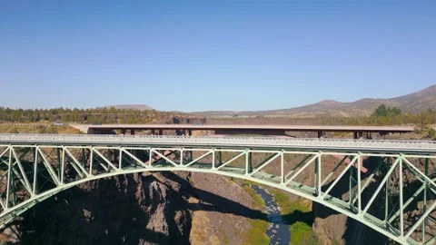 Drone shot flies over a deep valley and 2 bridges with cars driving across Stock Footage 318476994