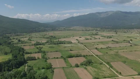 Drone shot fly over fields during summer between mountains in greece Видео 338127651