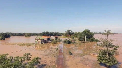 Drone shot : fly up revealing a tiny flooded hamlet on the edge of the river Video stock 87289651