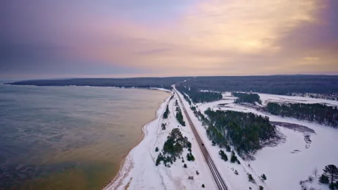 Drone shot flying along desolate US highway 2 in Northern Michigan with Lake Vídeos de archivo 334765639