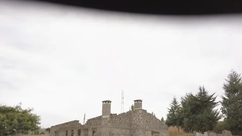 Drone shot flying up and over a old ruined farmhouse in South Sudan near a field Stock-Footage 249348645