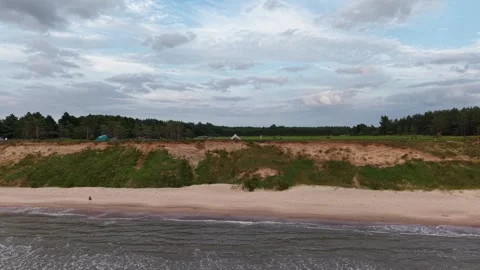 Drone shot flying away from steep sand cliff camping grounds, Latvia Kurzeme Stock Footage 341770213