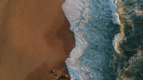 Drone shot flying backwards over waves on sandy beach in summer Stock Footage 95039841