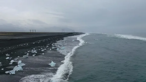 Drone shot, flying backwards over the icebergs on Diamond beach, Iceland Stock Footage 112441555