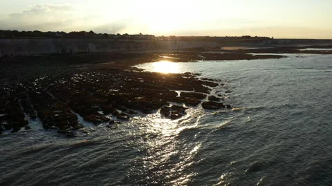 Drone shot flying backwards over rocks and sea at sunset. Stock Footage 146742684