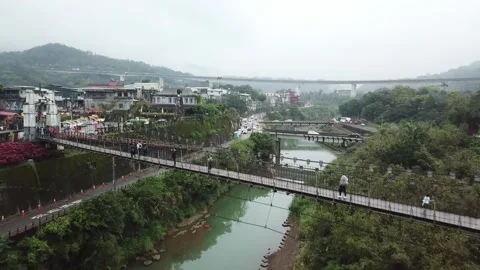 Drone shot flying over a bridge, revealing small town and cars driving (Taiwan) Stockbeeldmateriaal 329052296