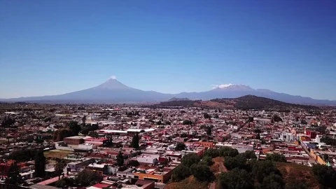 Drone shot flying over Cholula, Mexico to the volcano Popocatepetl. Stock Footage