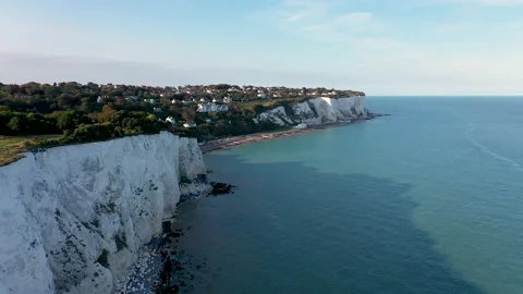 Drone shot flying over cliffs and the sea revealing bay and countryside. 4k Stock Footage 147364761